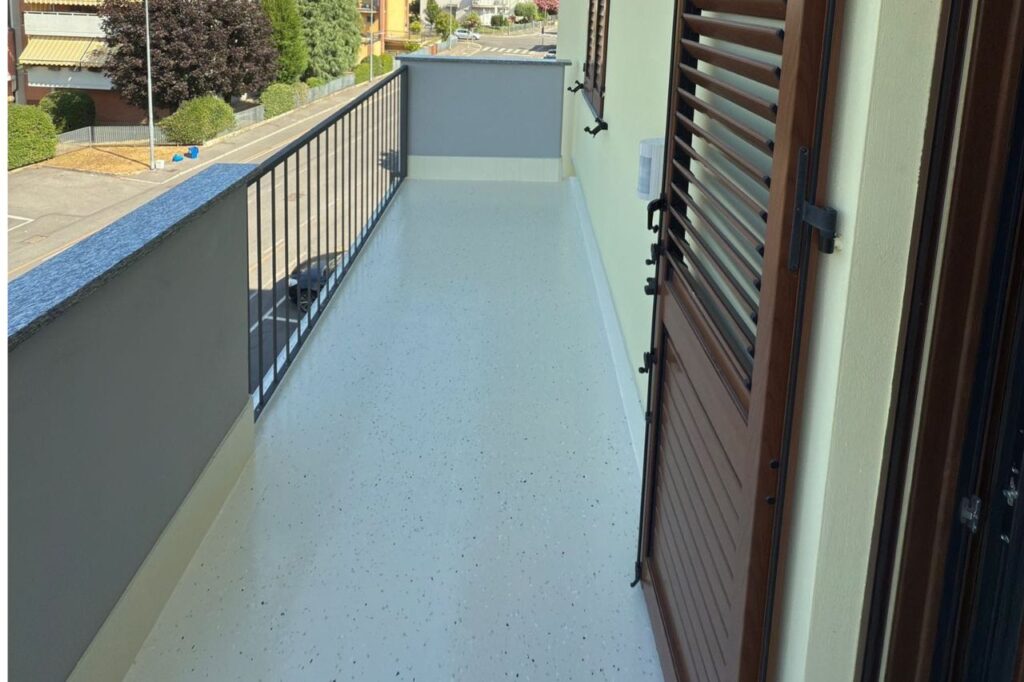 Texture in primo piano di una pavimentazione in resina decorativa per esterni con finitura effetto pietra granigliata, resistente e antiscivolo