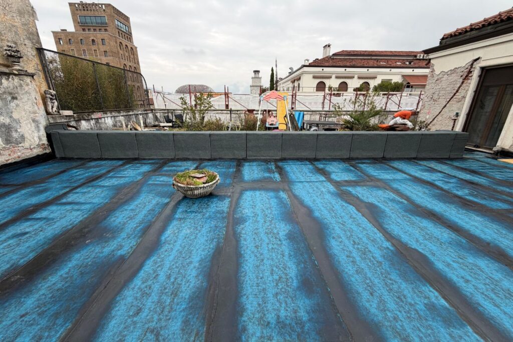 Impermeabilizzazione terrazzo calpestabile con finitura in resina blu resistente alle intemperie.